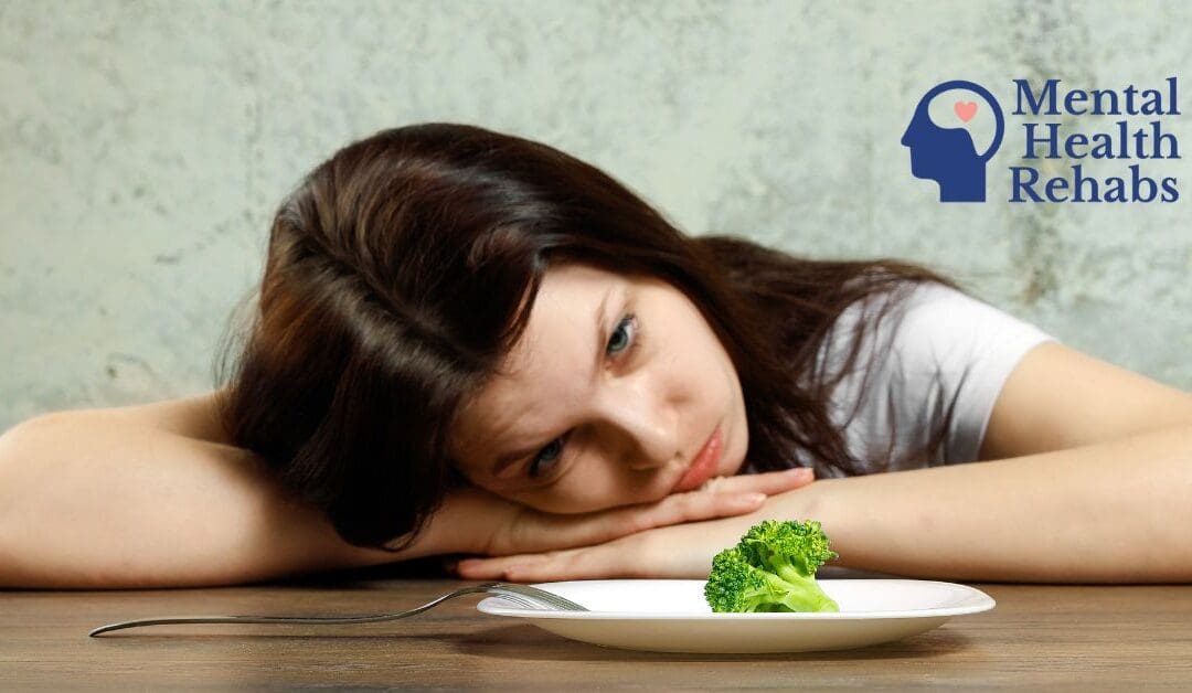 an image of a girl leaned over looking at a plate with a piece of brocolli on it.